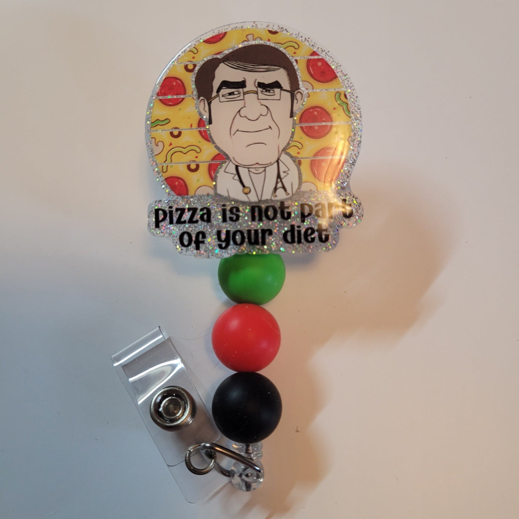 Badge holder with cartoon character and text 'Pizza is not part of your diet' on a yellow background.