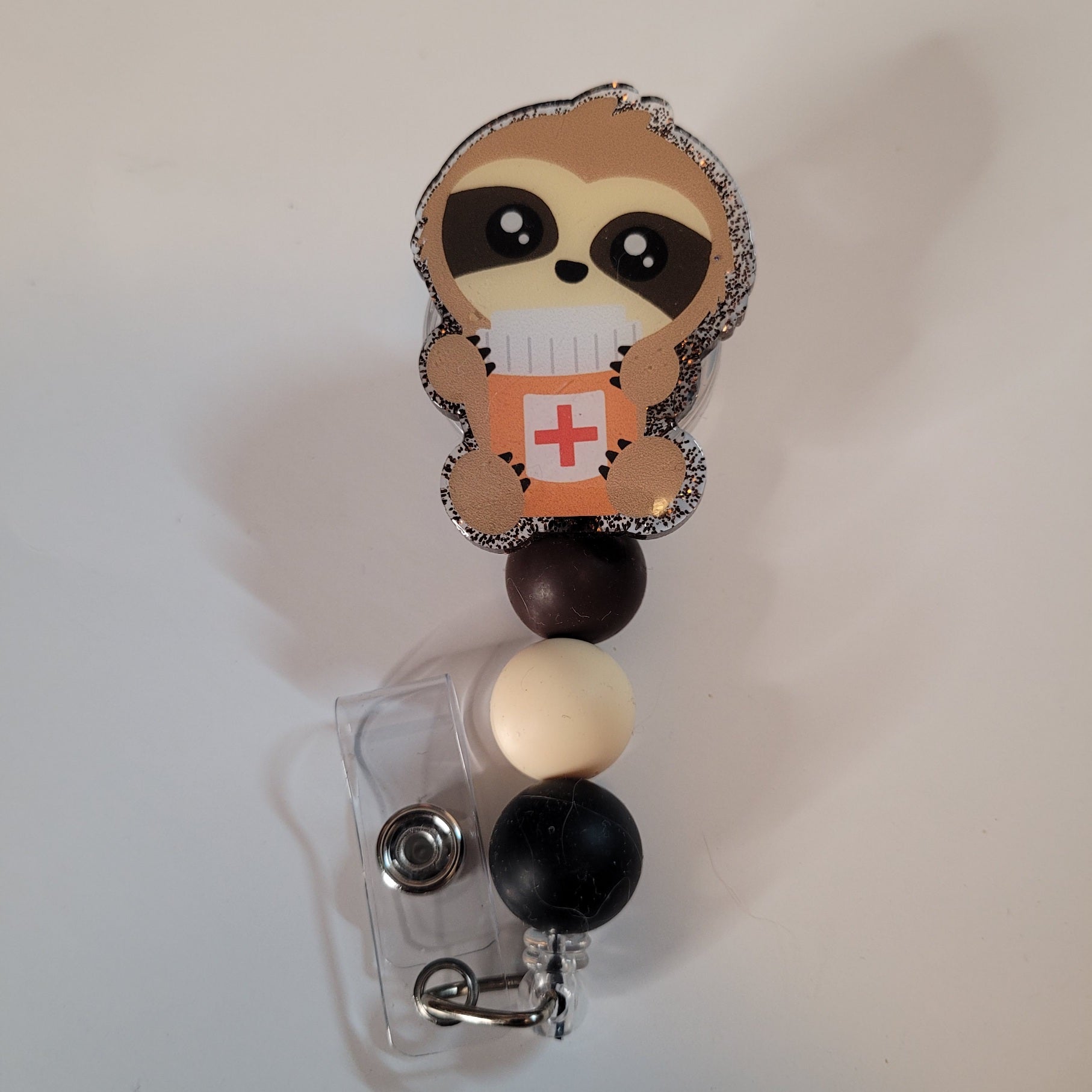 Retractable badge holder with sloth design on a white background