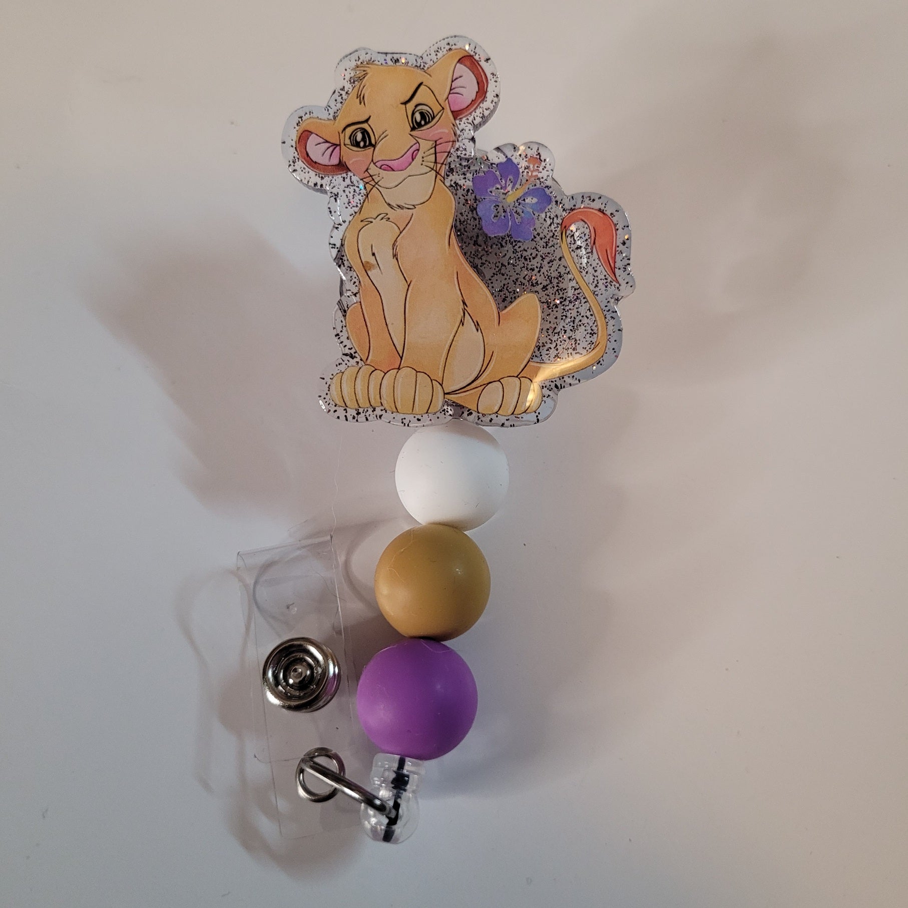 Badge holder with cartoon character and colorful beads on a white background