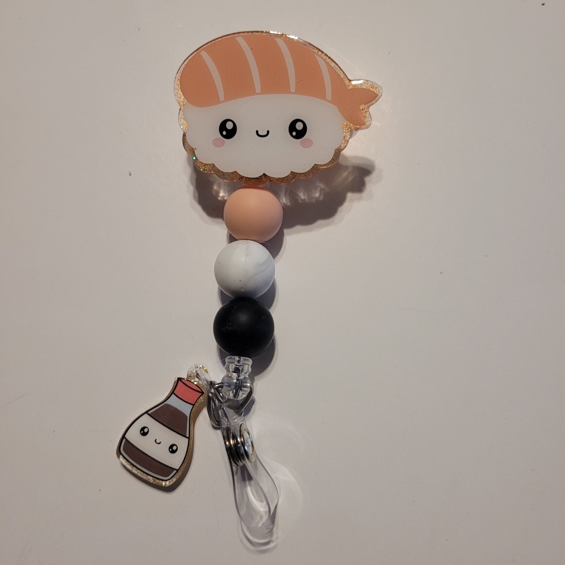 Kawaii-themed pacifier clip with a cloud design on a white background
