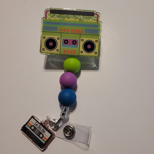 Colorful badge holder with a retro radio design, beads, and a cassette tape charm on a white background.
