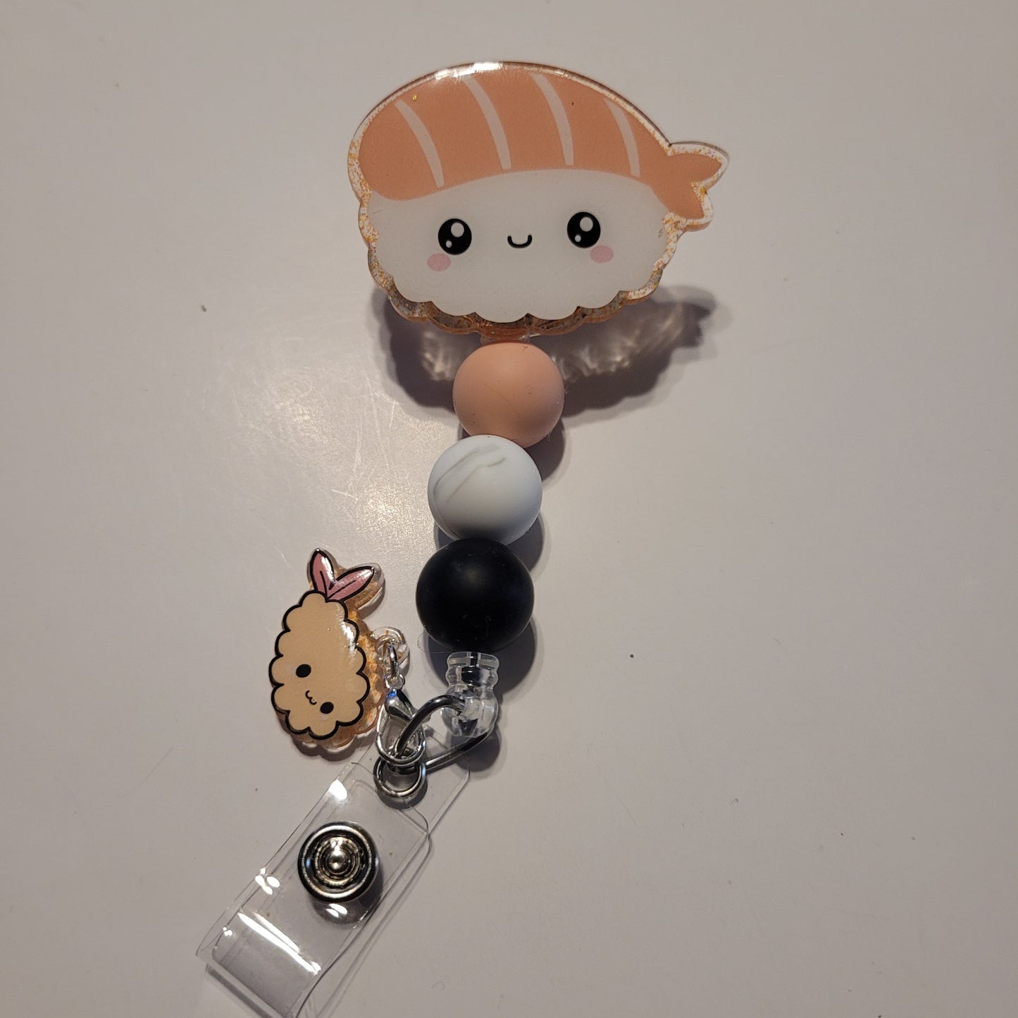 Retractable badge holder with cartoon character charm on a white background