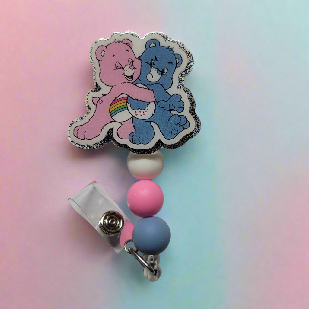 Looking for a charming badge reel? Well, look no further because we've got our Bear Hug Bears here! So cute with Rainbow Bear putting a hug on Grumpy Bear. With a glittery back and 3 matching silicone beads, it's perfect for all the bear lovers out there.