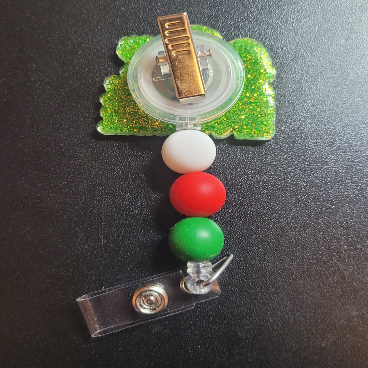 Not sure which of Santa's lists you made? Negotiate! Just in time for the holidays we bring you the Dear Santa Let's Negotiate badge reel. A green glitter back and 3 silicone matching beads An excellent choice for a stocking stuffer.
