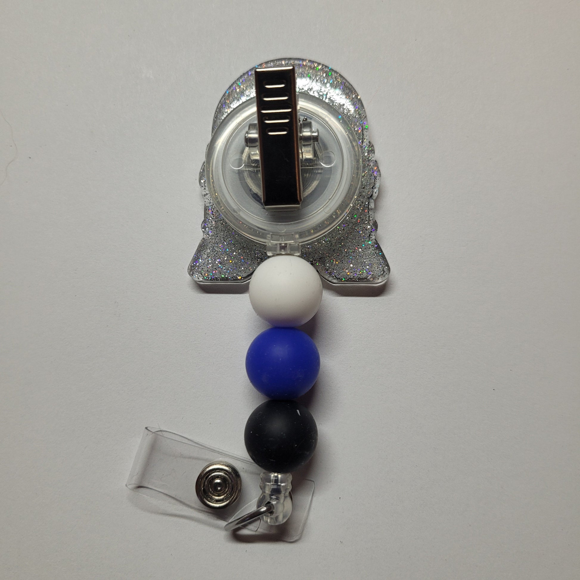 Unleash your inner power and wield this Droid to rescue the Universe! This little guy is dressed up in a shiny glitter back and adorned with 3 silicone beads.