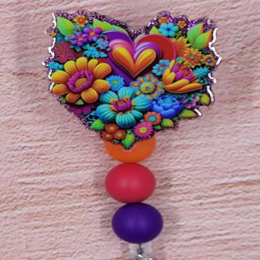 This Badge Reel utilizes an attractive floral pattern in a bold color palette. The design is complemented by a purple glitter base and three coordinated silicone beads.
