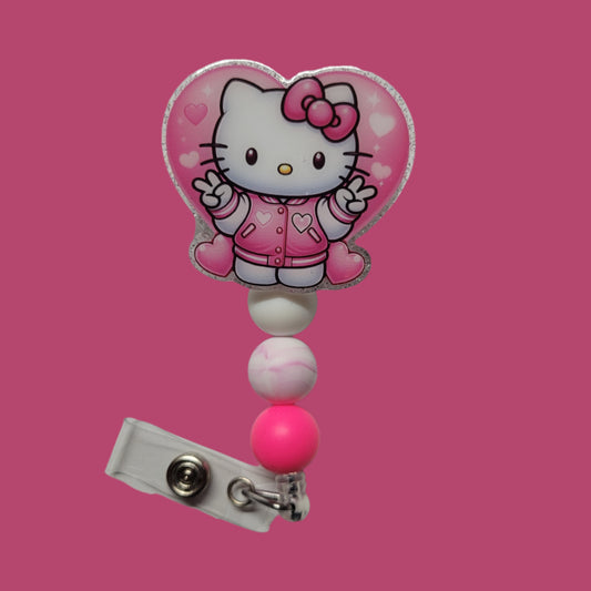 By popular demand we bring you a new series of Kitty Badge Reels. Here is our Love Kitty sporting a Pink jacket with a heart and her flashing you peace signs and a pink ribbon in her hair. Light Pink glitter on the back and 3 silicone beads finish the look.