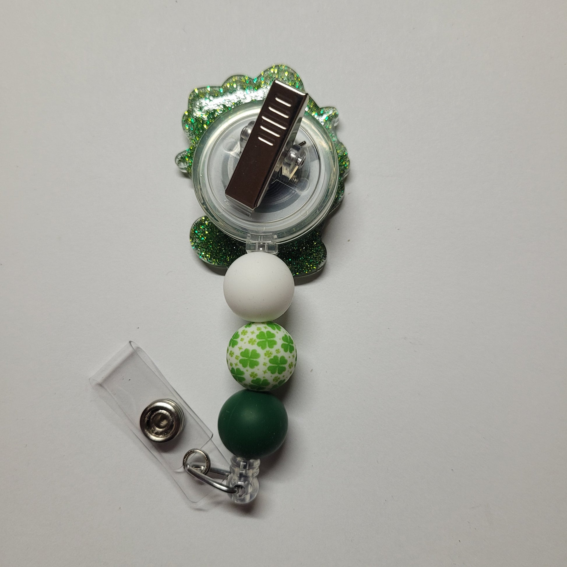 By popular demand we bring you a new series of Kitty Badge Reels. Here is our Lucky Kitty sporting a green clover adorned jacket and green ribbon in her hair. Green glitter on the back and 3 silicone beads, 1 of which is a clover focal bead, finish the look.