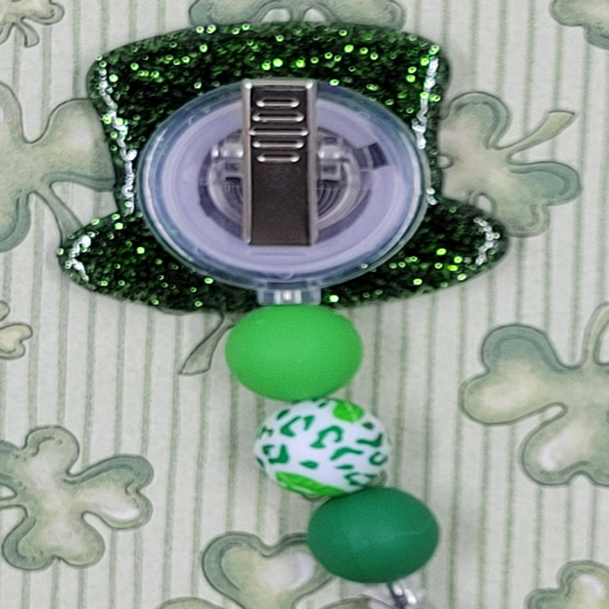 Celebrate St. Patrick's Day with our Leprechaun Hat badge reel. This classic hat features a dark green glitter base and 3 coordinating fun and lucky silicone beads for a festive, professional look.