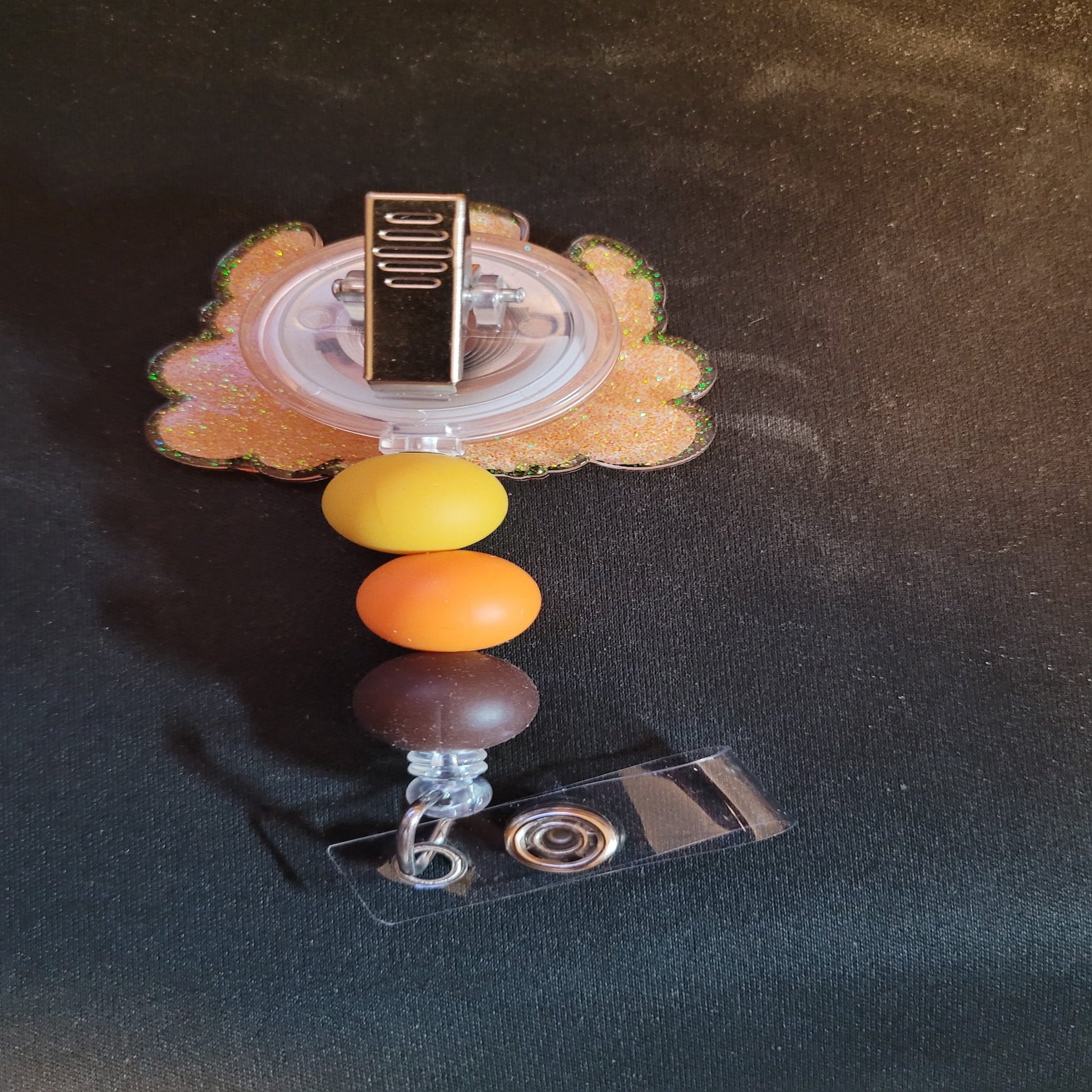 What would Thanksgiving be without a Turkey Stitch. This badge reel has a shiny glitter base and is finished with 3 color coordinated silicone beads.