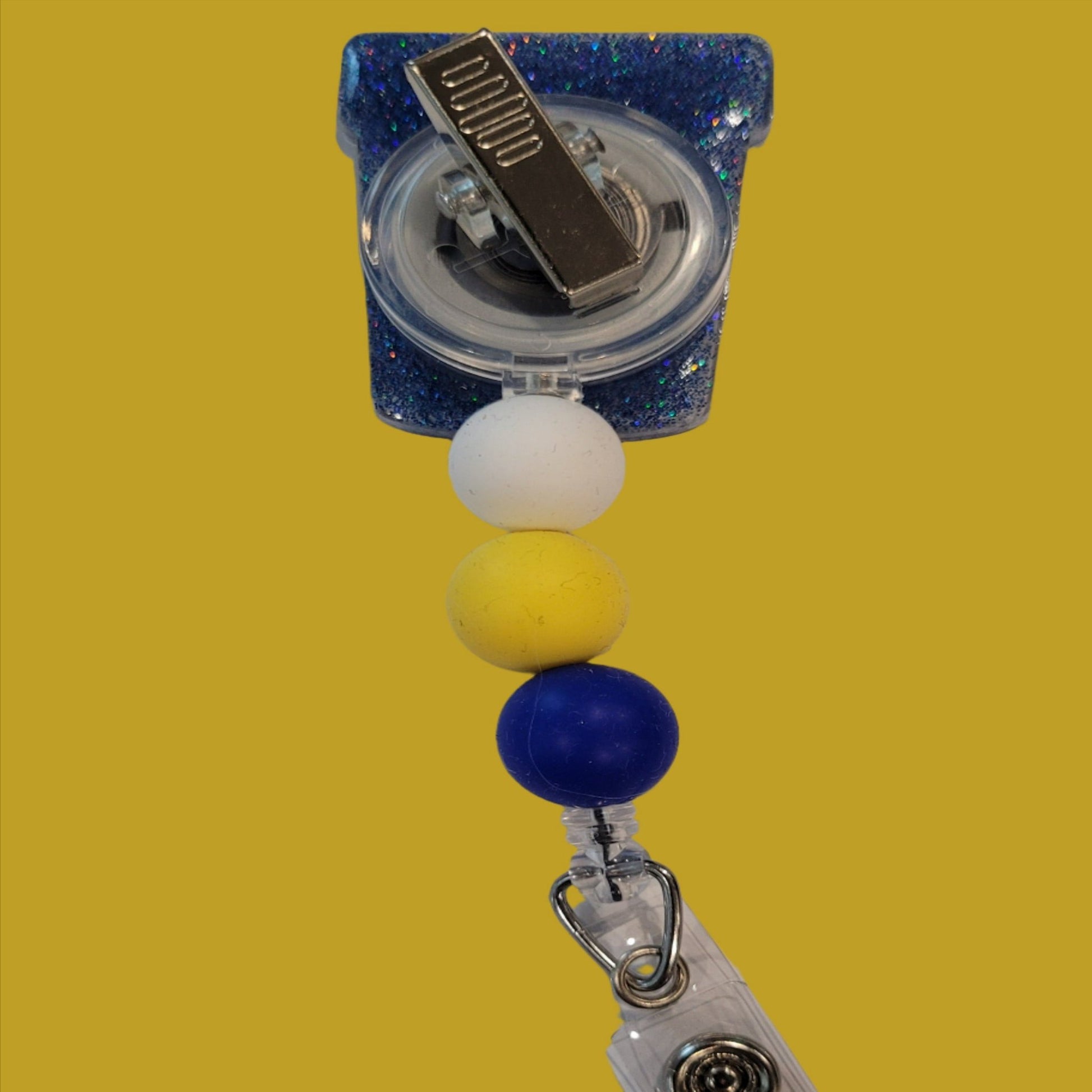Part of our latest collection of Medical Badge Reels available now, we will need this filled for the Urine Good Hands Badge Reel. Featuring a collection cop and a light blue glitter base adorned with coordinating beads, this Badge Reel is sure to catch....well we will leave that alone.