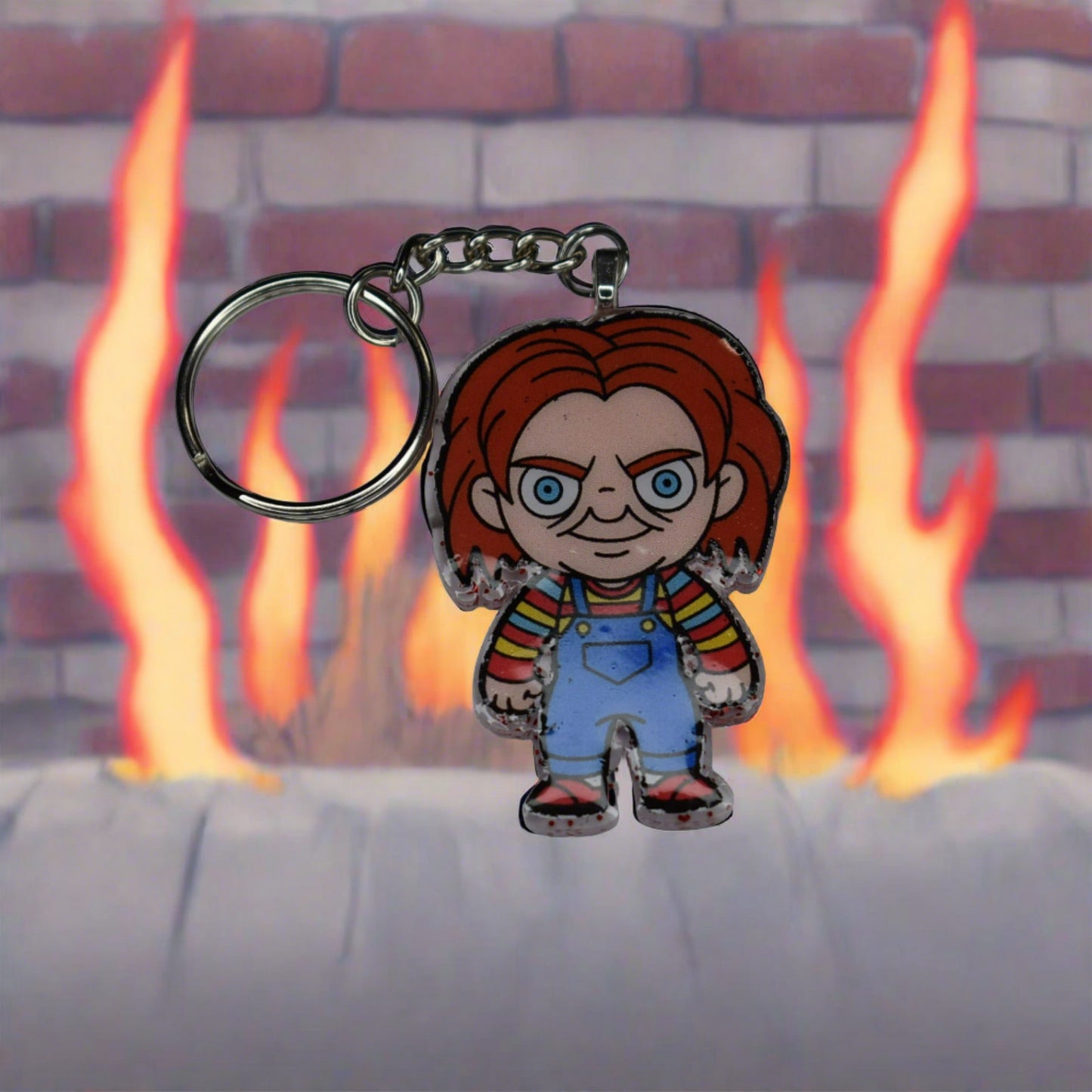 From our Horror Collection here is Chucky. There is nothing good about this guy. Trapped in a doll he craves to kill to regain his human form. This Keychain features a Blood red glitter back and that crazy red headed doll in overhauls on the front. Hand crafted from acrylic resin to be strong, like Chucky's need and desire to kill.