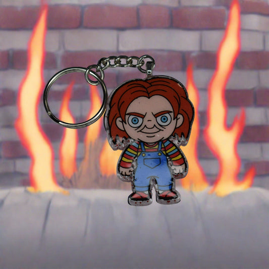 From our Horror Collection here is Chucky. There is nothing good about this guy. Trapped in a doll he craves to kill to regain his human form. This Keychain features a Blood red glitter back and that crazy red headed doll in overhauls on the front. Hand crafted from acrylic resin to be strong, like Chucky's need and desire to kill.