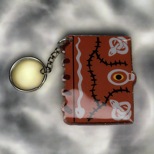 The Sanderson Sisters are lost without this Spell Book Keychain. Made from sturdy acrylic resin. This keychain will put a spell on you.