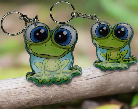 This Frog Keychain is hopping with happiness! Made from durable acrylic resin he comes with a green glitter background and a great happy smile. Available in 2 sizes. Small measures 1.5" x 2" and the large at 2" x 2.5".