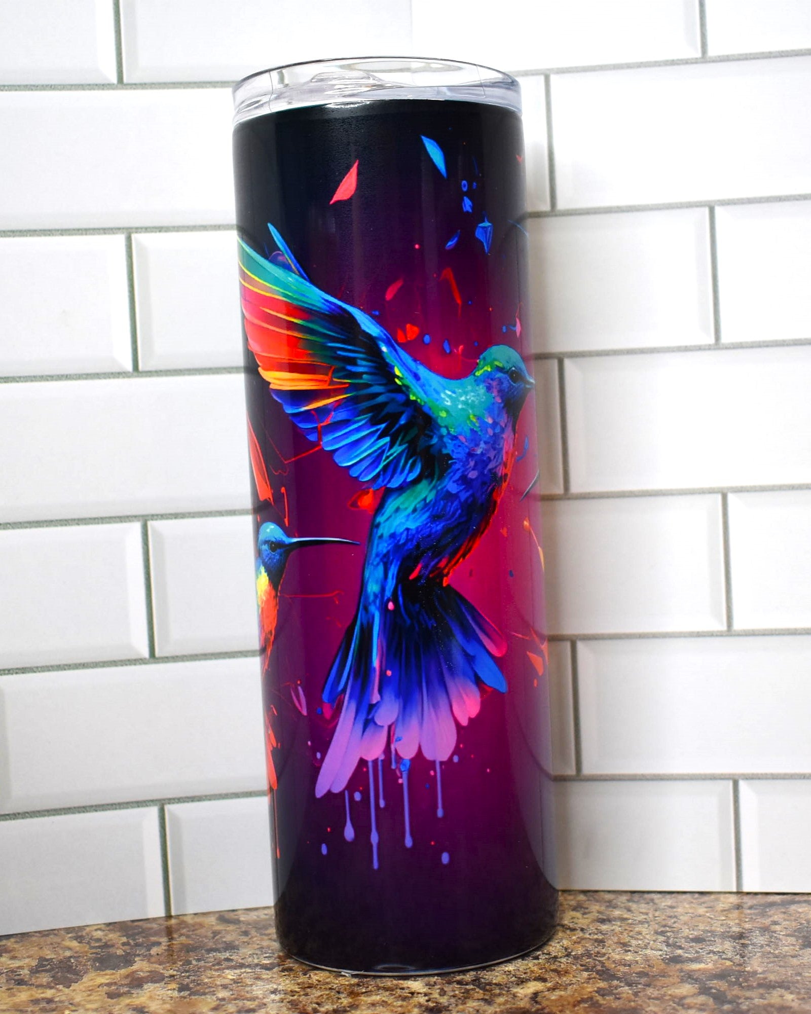 Hummingbirds dripping of paint are featured here on this Makerflo 20 oz tumbler. 