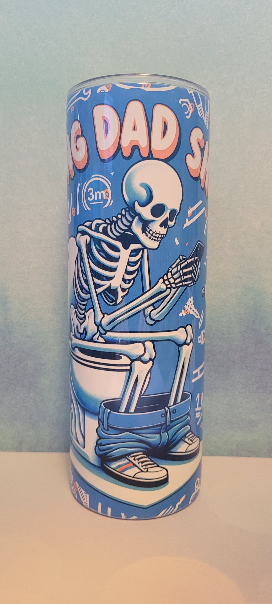 Doing Dad Shit. Just as it says. A Dad skeleton sitting on the throne will catching up on social media. A blue background with various tools a dad uses all the time fully wraps