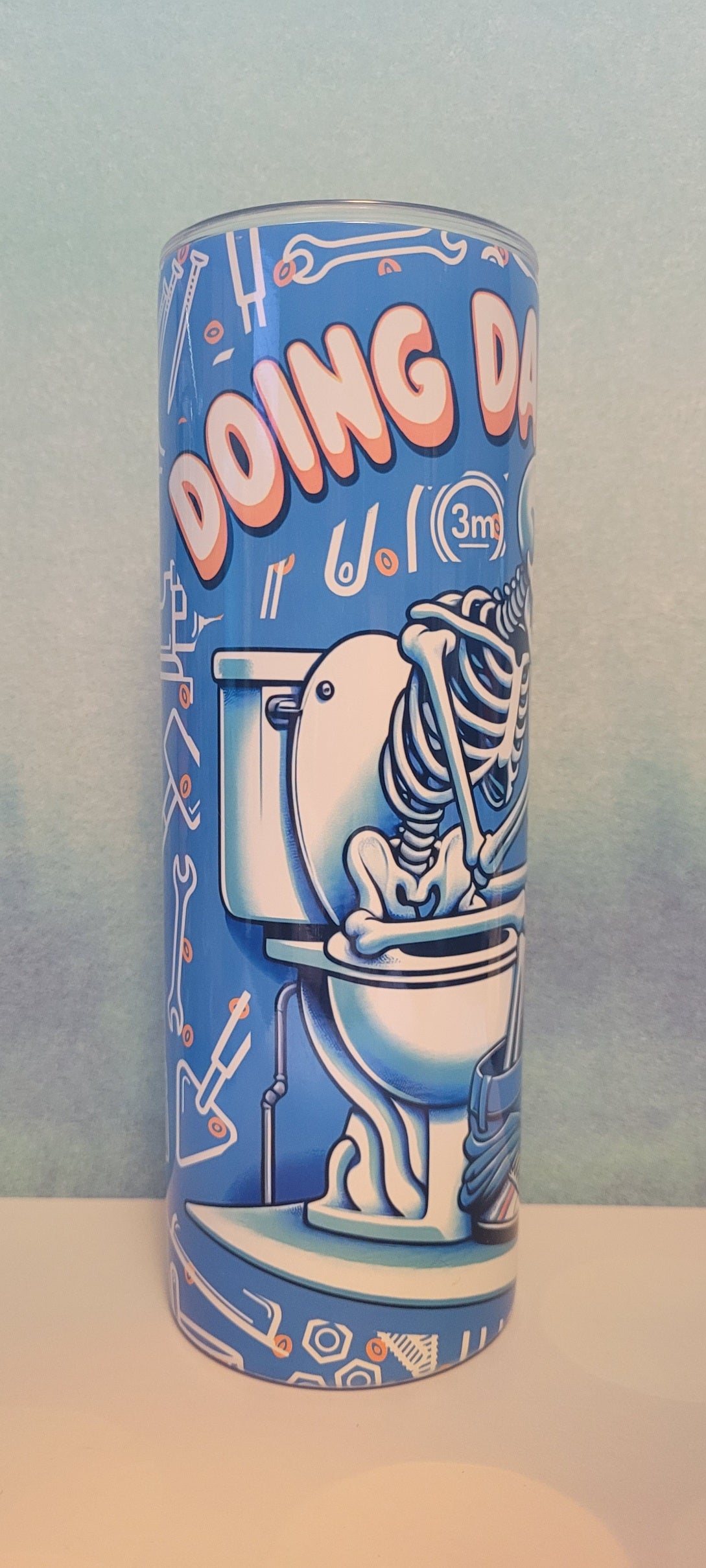 Doing Dad Shit. Just as it says. A Dad skeleton sitting on the throne will catching up on social media. A blue background with various tools a dad uses all the time fully wraps