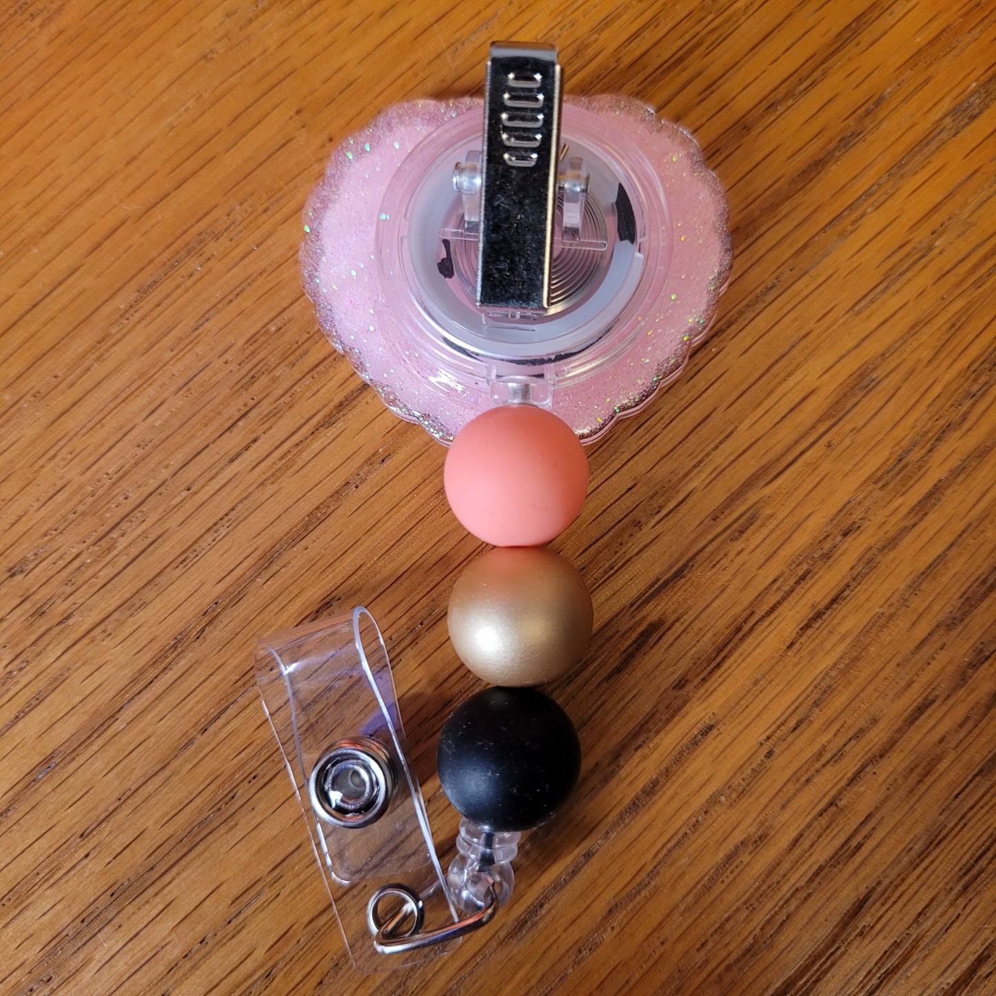 Another new one to our Animal Series... Bee Heart. This badge reel features a heart shaped base with a honey bee centered in a border full of daisies. A dazzling pink glitter backing and 3 color-coordinated silicone beads add the perfect finishing touch to this badge reel.