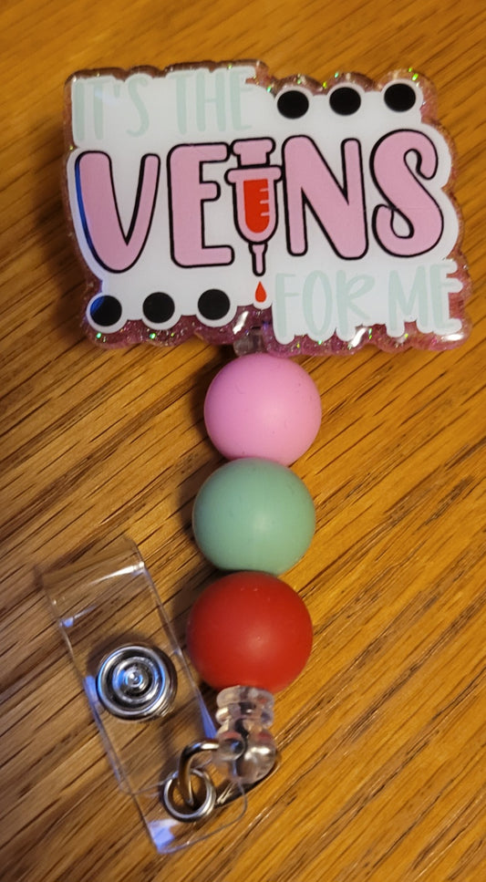 Now Part of our Medical Badge Reels collection, we have available, Veins For Me. Perfect for every Phlebologist. Featuring the phrase It's The Veins For Me on the front with a pink glitter base on the back adorned with 3 coordinating silicone beads.