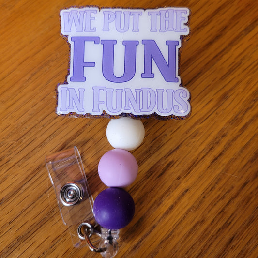 On this badge reel in our Medical Series we put the words We Put The Fun In Fundus....purple hues on a white base. Now if you know what Fundus means you can fun with this one. A purple glitter backing and 3 color-coordinated silicone beads add the perfect finishing touch to this badge reel.