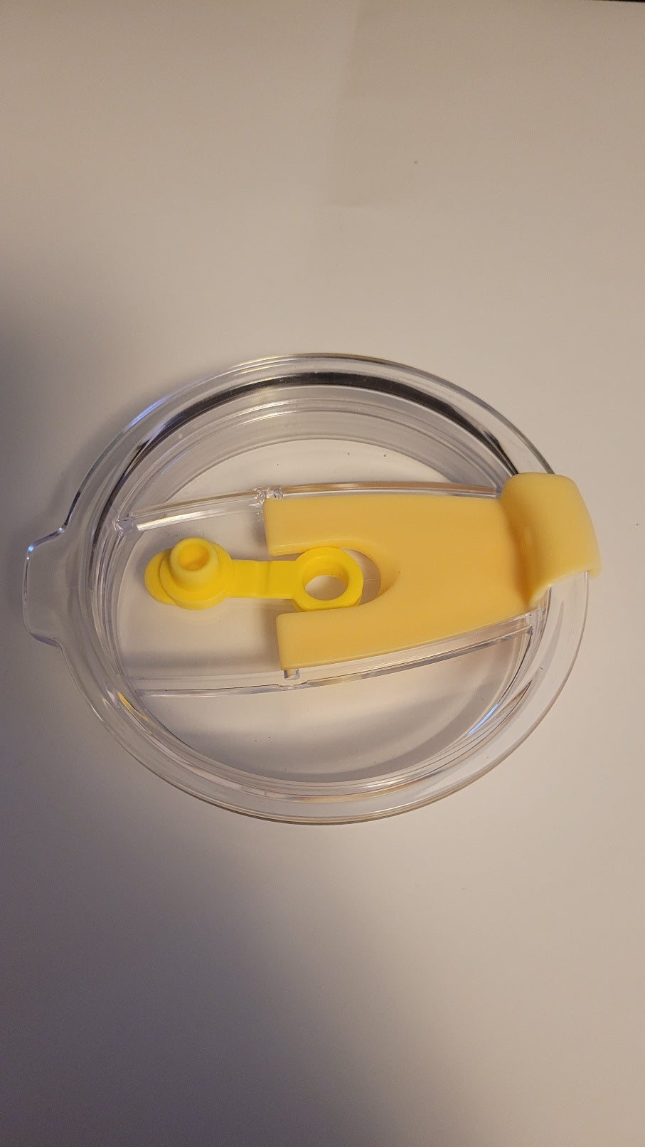Clear plastic lid with yellow handle on a white background