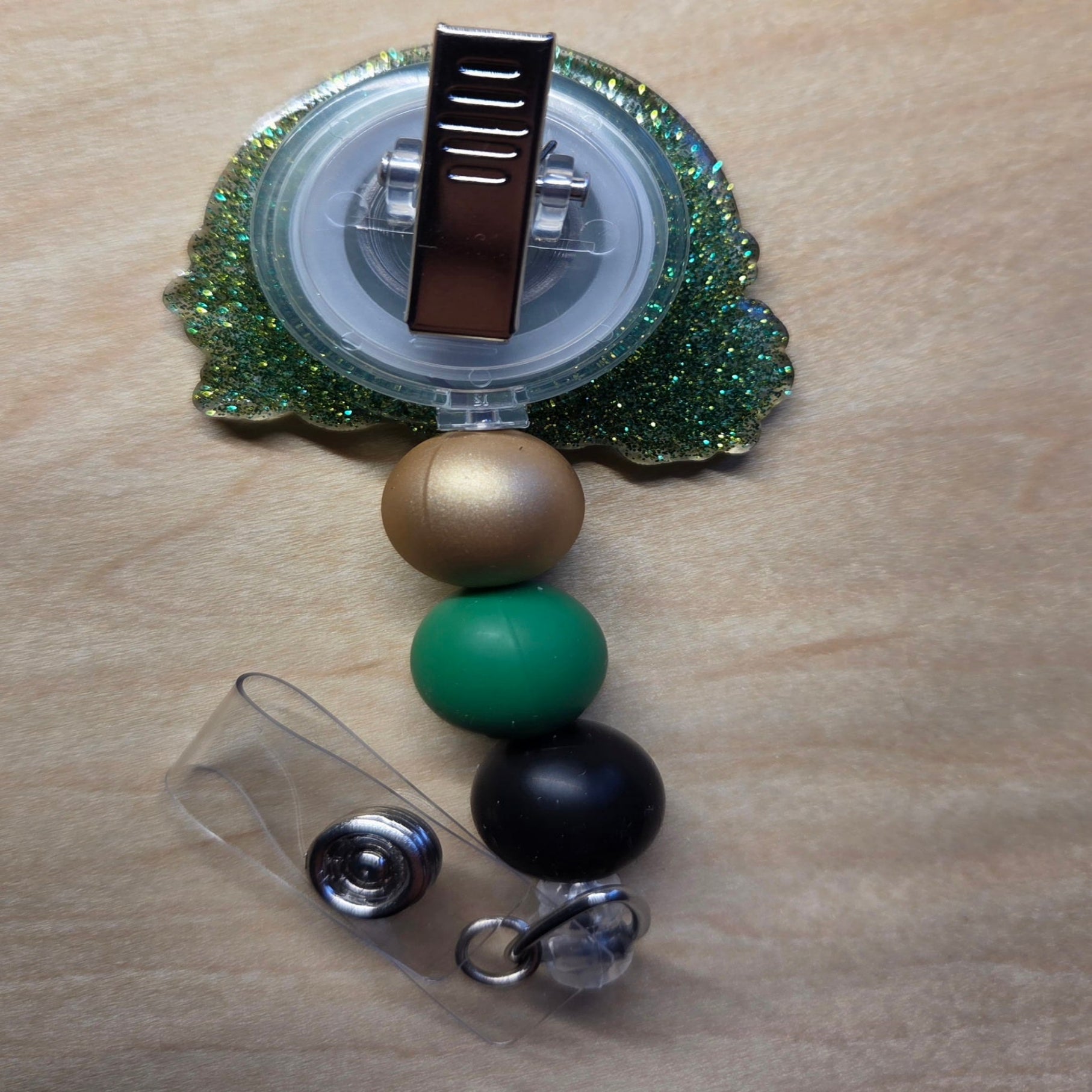 Decorative badge holder with colorful beads on a wooden surface