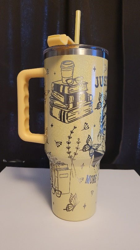Yellow tumbler with handle and straw on a black background