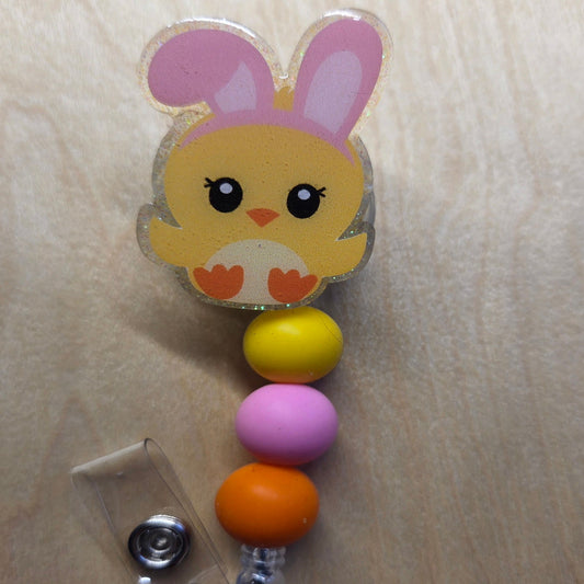 Colorful badge holder with a cartoon chick design on a beige background