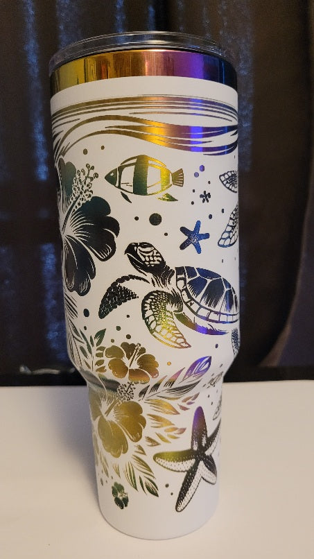 Introducing the latest addition to our collection: the 40 oz Gold Plated Tumbler featuring laser-etched full-wrap from another on a sleek white background. 3 sea turtles swimming around other sea life