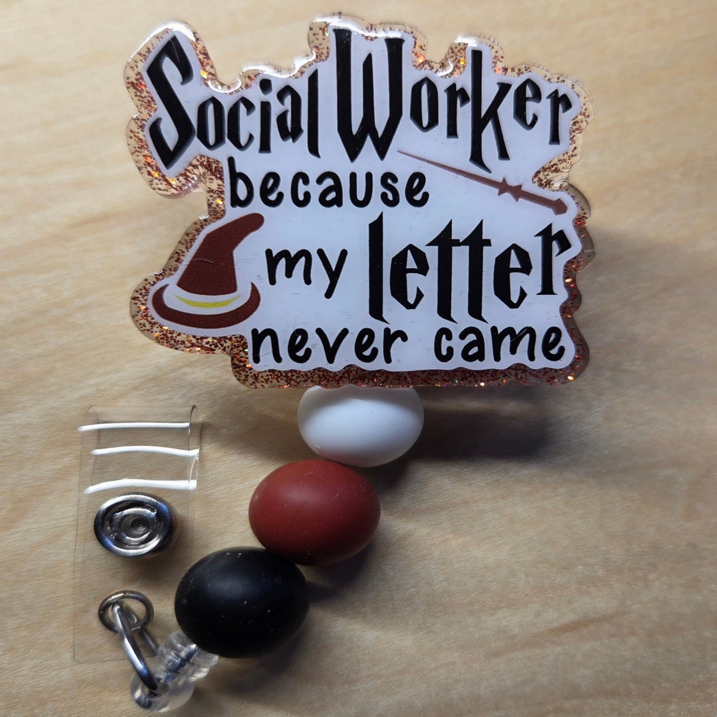 Badge with 'Social Worker because my letter never came' text on a wooden background