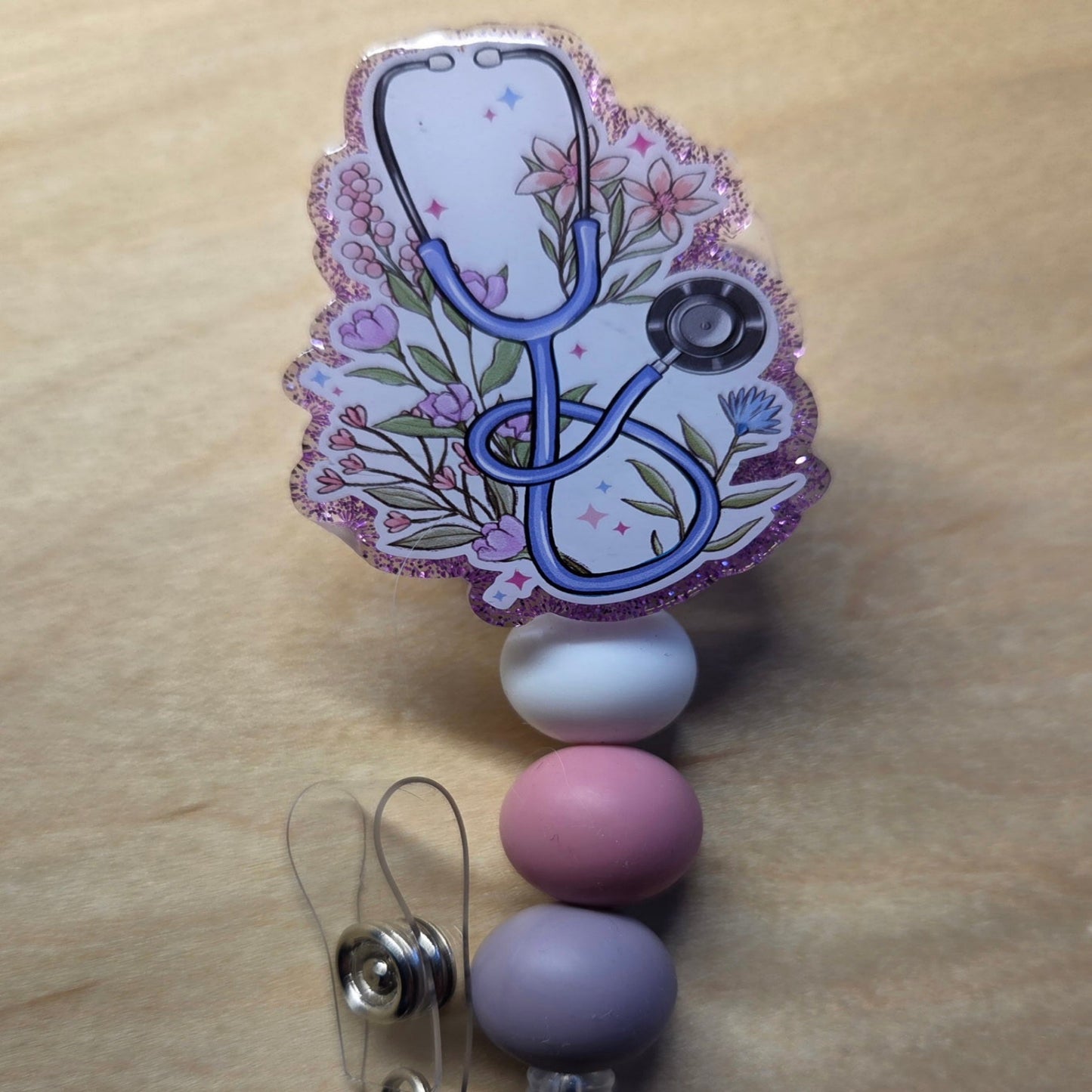 Decorative badge holder with stethoscope design on a wooden surface