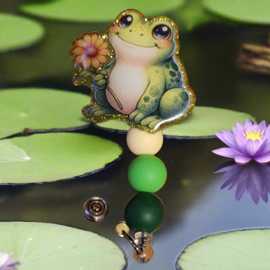 Another new one to our Animal Series... Daisy Frog. This cute frog is smiling away while holding a pretty daisy. A dazzling green glitter backing and 3 color-coordinated silicone beads add the perfect finishing touch to this out-of-this-world badge reel.