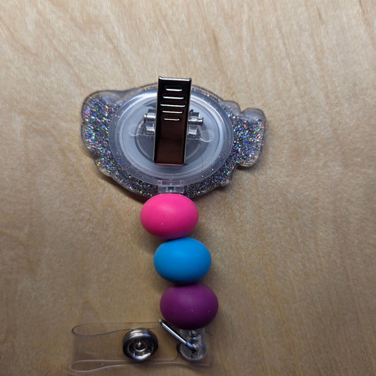 Decorative badge holder with colorful beads on a wooden surface