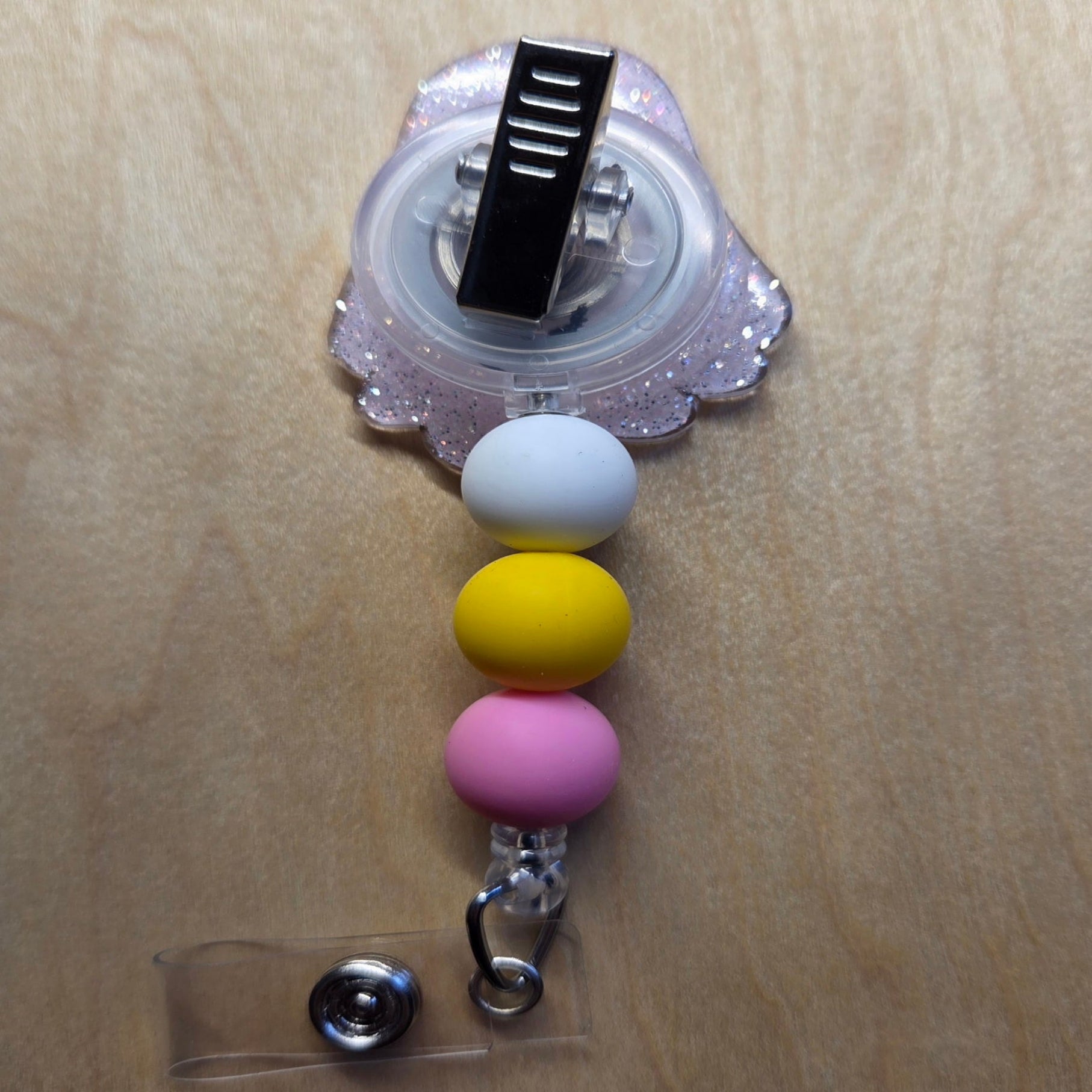 Colorful beaded keychain with a clip on a wooden surface