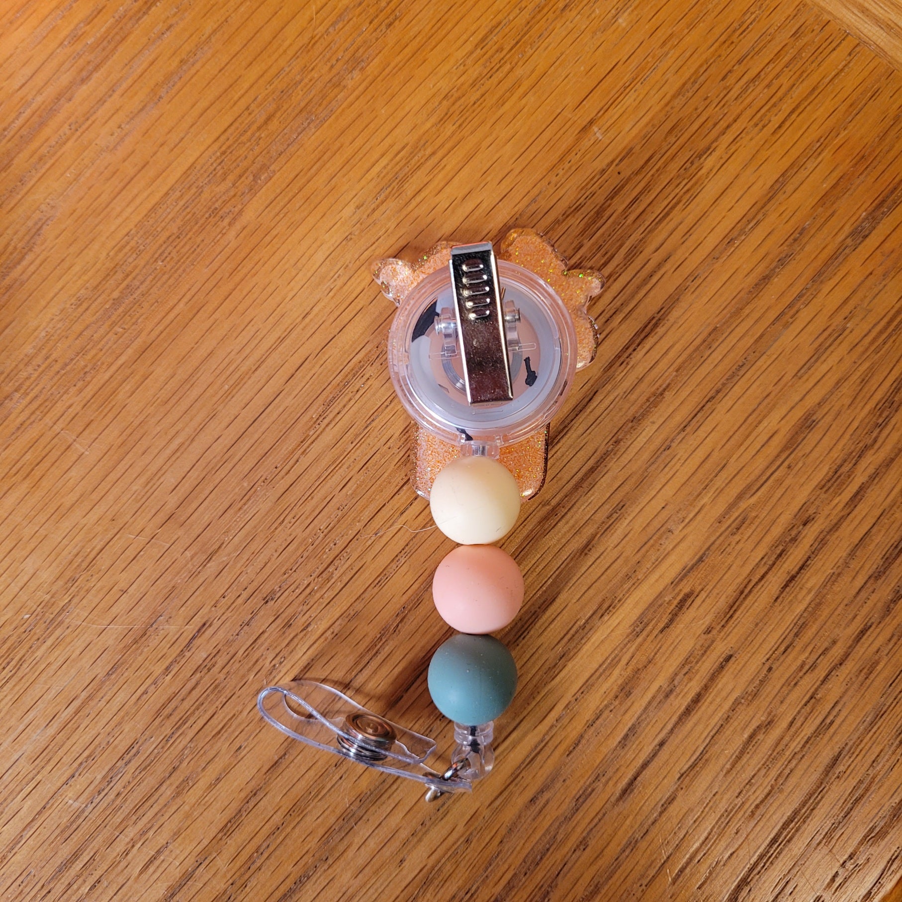 Our Mason Jar Vase badge reel is here. With various flowers in a mason jar used as a vase. A sparkling peach glitter back and embellished with 3 silicone beads on the cord.