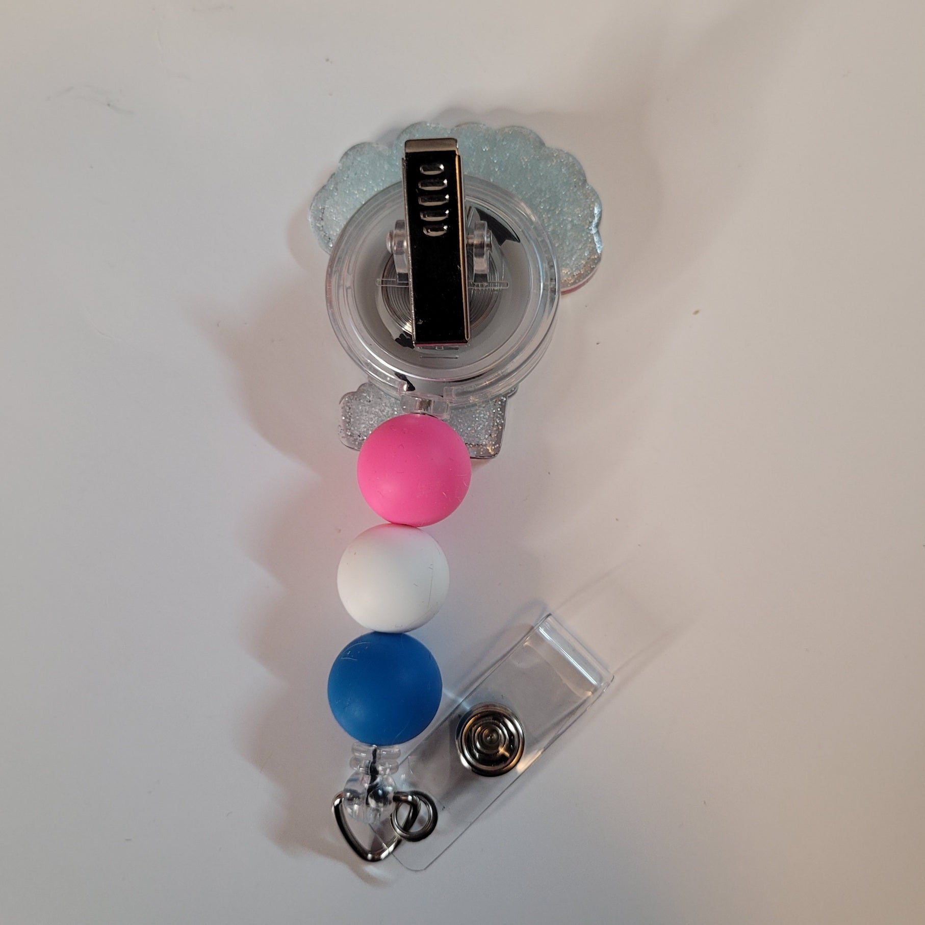 Retractable badge holder with colorful beads on a white background