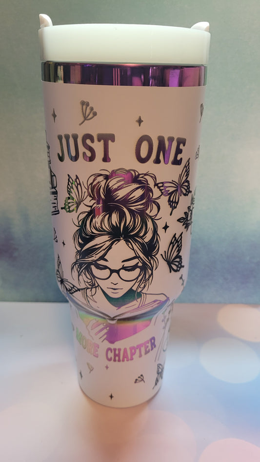 Tumbler with a design of a woman with glasses and text 'Just One More Chapter' on a gradient background.