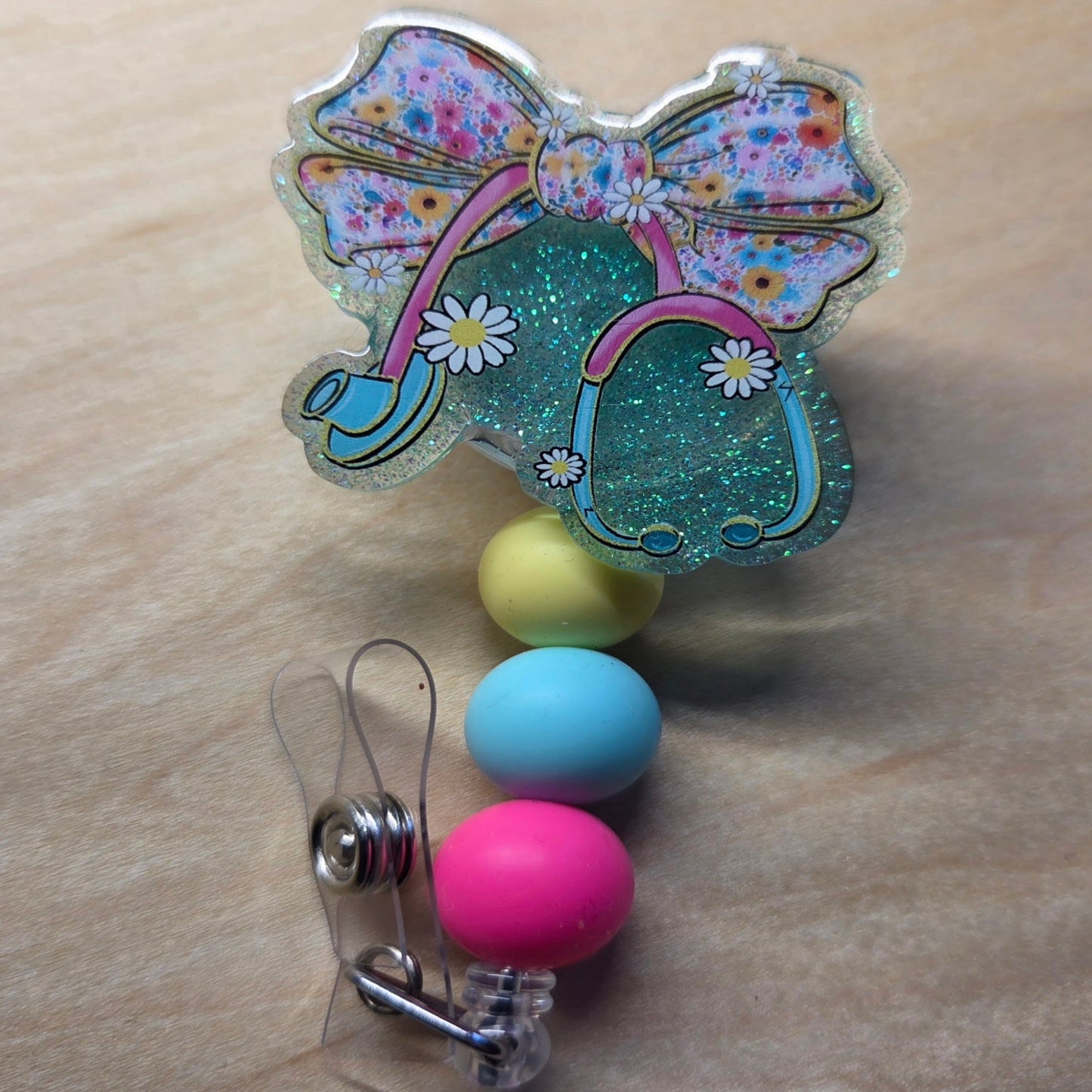 Colorful badge holder with a bow design on a wooden surface
