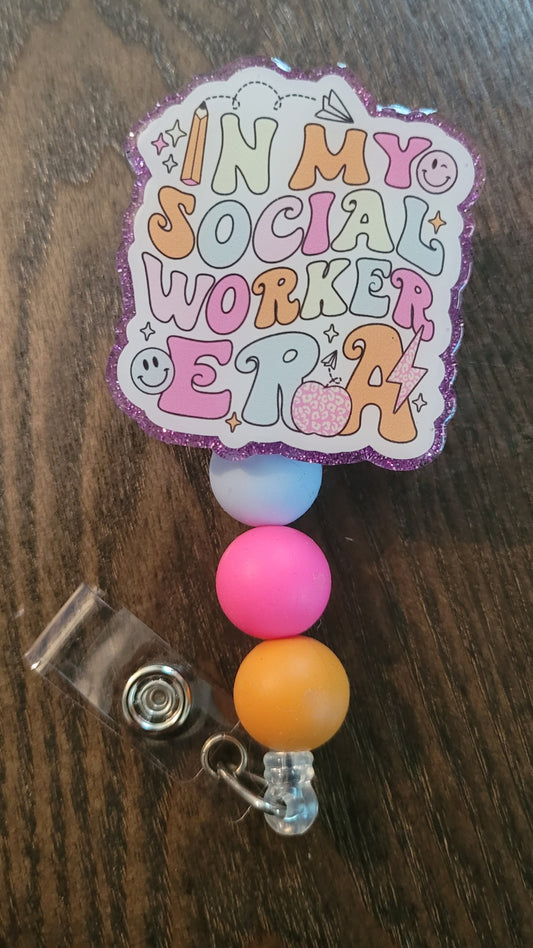 This badge reel speaks of the hard work and dedication to the Social Workers out there. The design element features a purple glitter background with lettering in a various colors accented by three silicone beads. In My Social Worker Era.