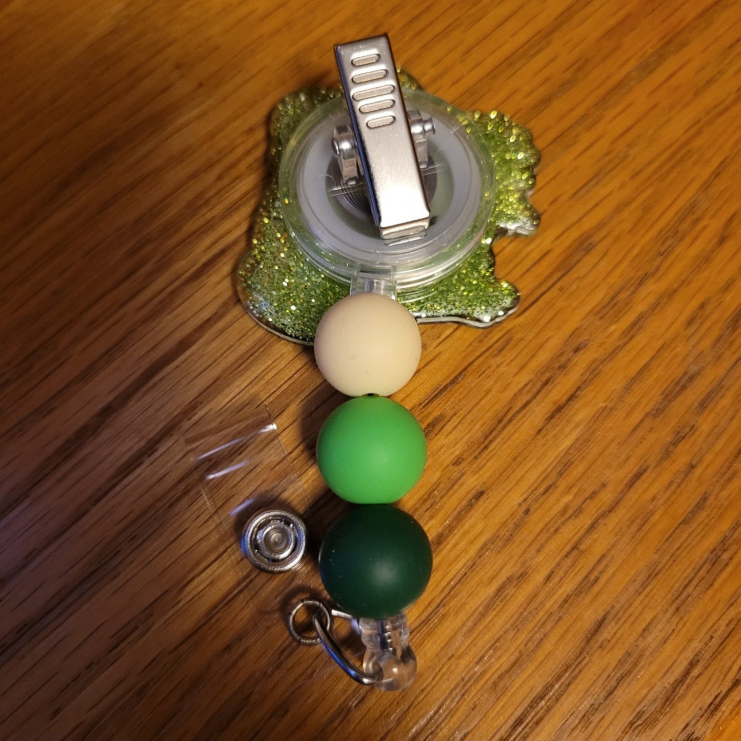 Another new one to our Animal Series... Daisy Frog. This cute frog is smiling away while holding a pretty daisy. A dazzling green glitter backing and 3 color-coordinated silicone beads add the perfect finishing touch to this out-of-this-world badge reel.