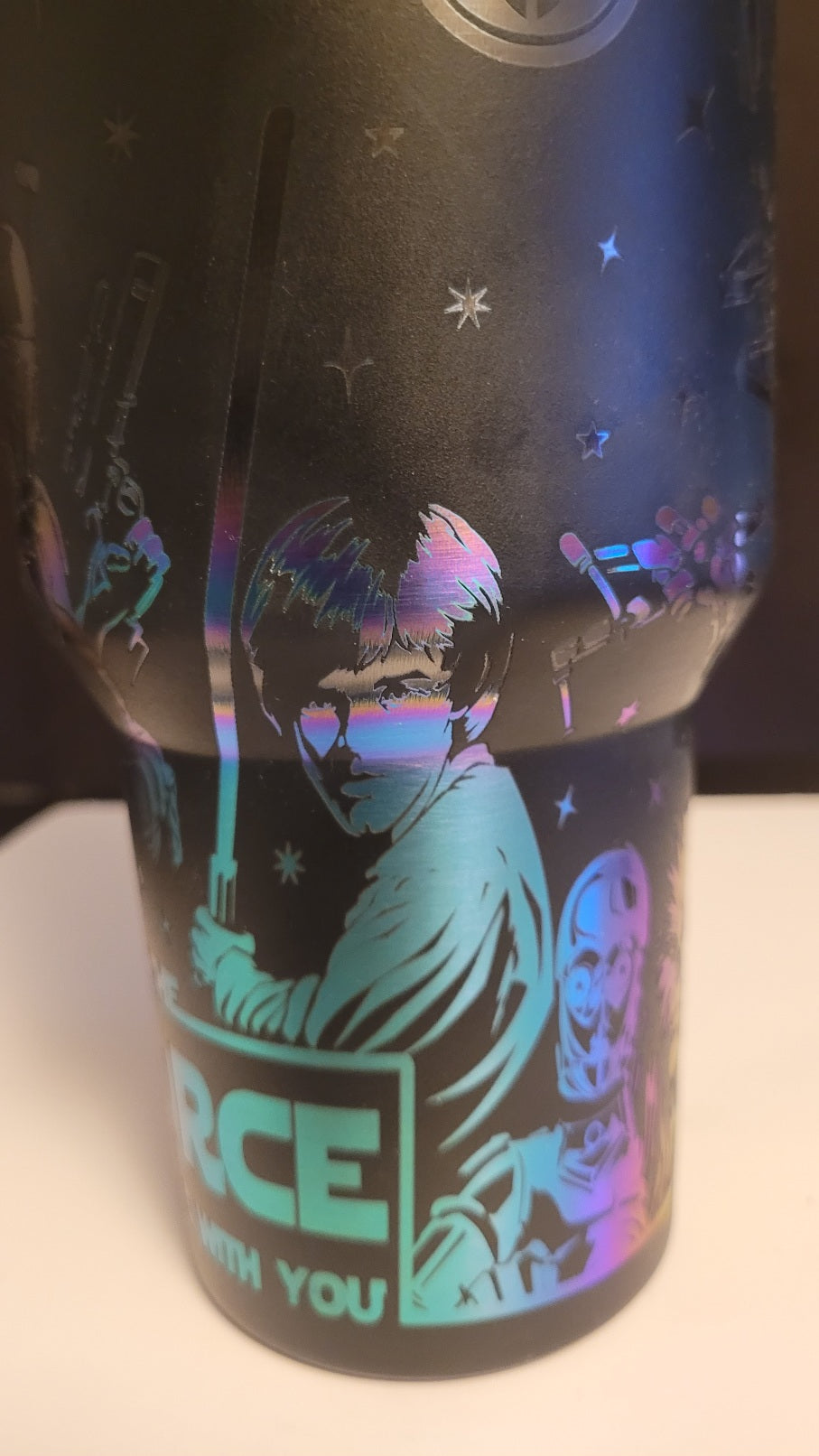 Black tumbler with colorful design and text on a white surface