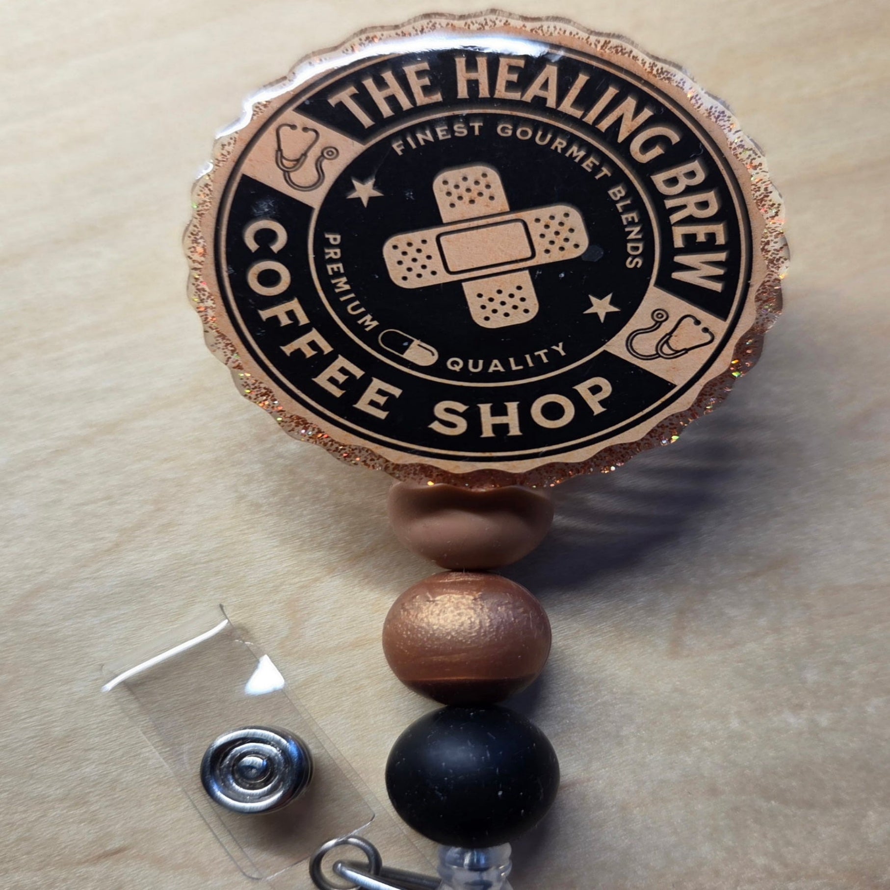 Badge holder with 'The Healing Brew Coffee Shop' branding on a beige background