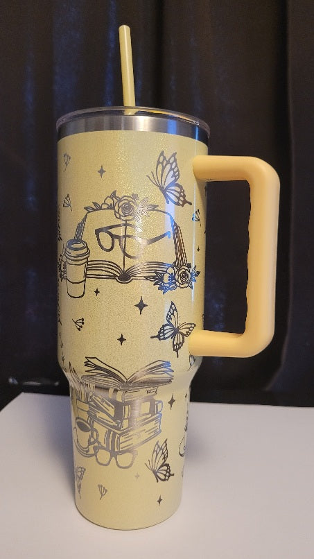 Yellow tumbler with handle and illustrations on a dark background