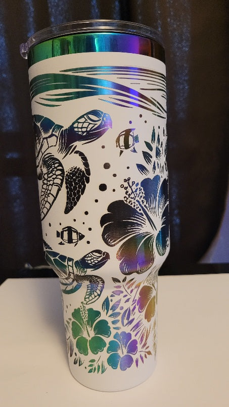 Introducing the latest addition to our collection: the 40 oz Gold Plated Tumbler featuring laser-etched full-wrap from another on a sleek white background. 3 sea turtles swimming around other sea life