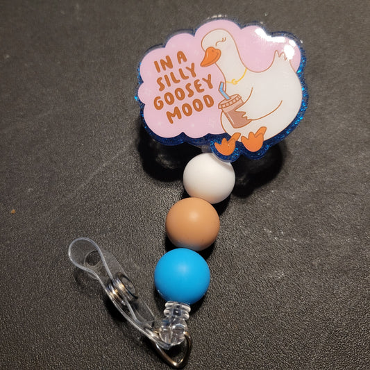 Retractable badge holder with cartoon duck and 'In a Silly Goosey Mood' text on a dark background