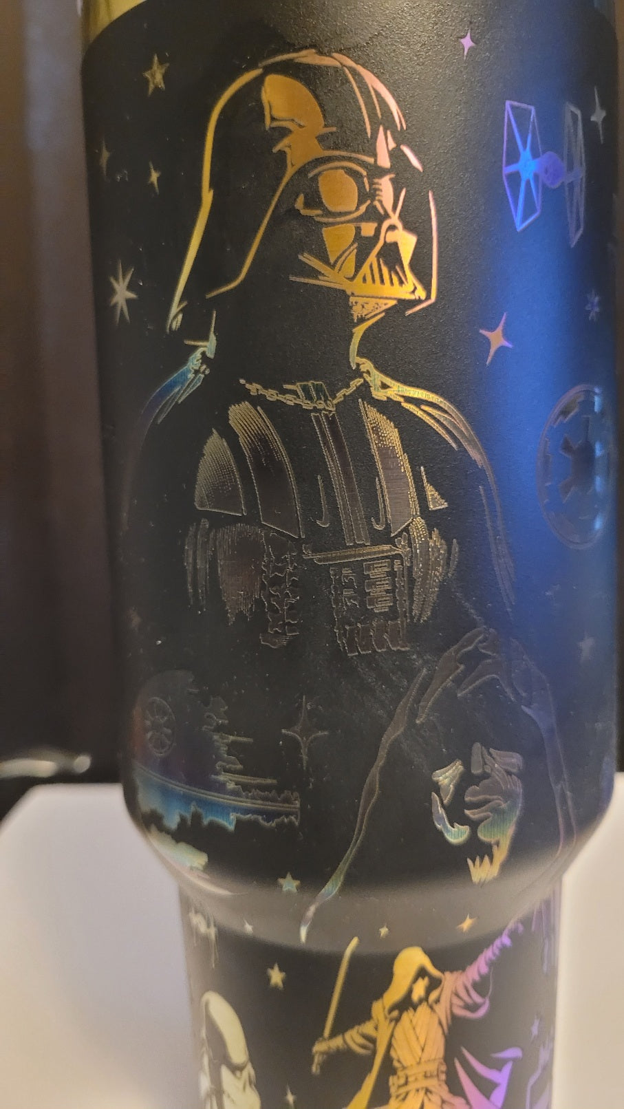 Tumbler with Darth Vader design and star patterns on a dark background