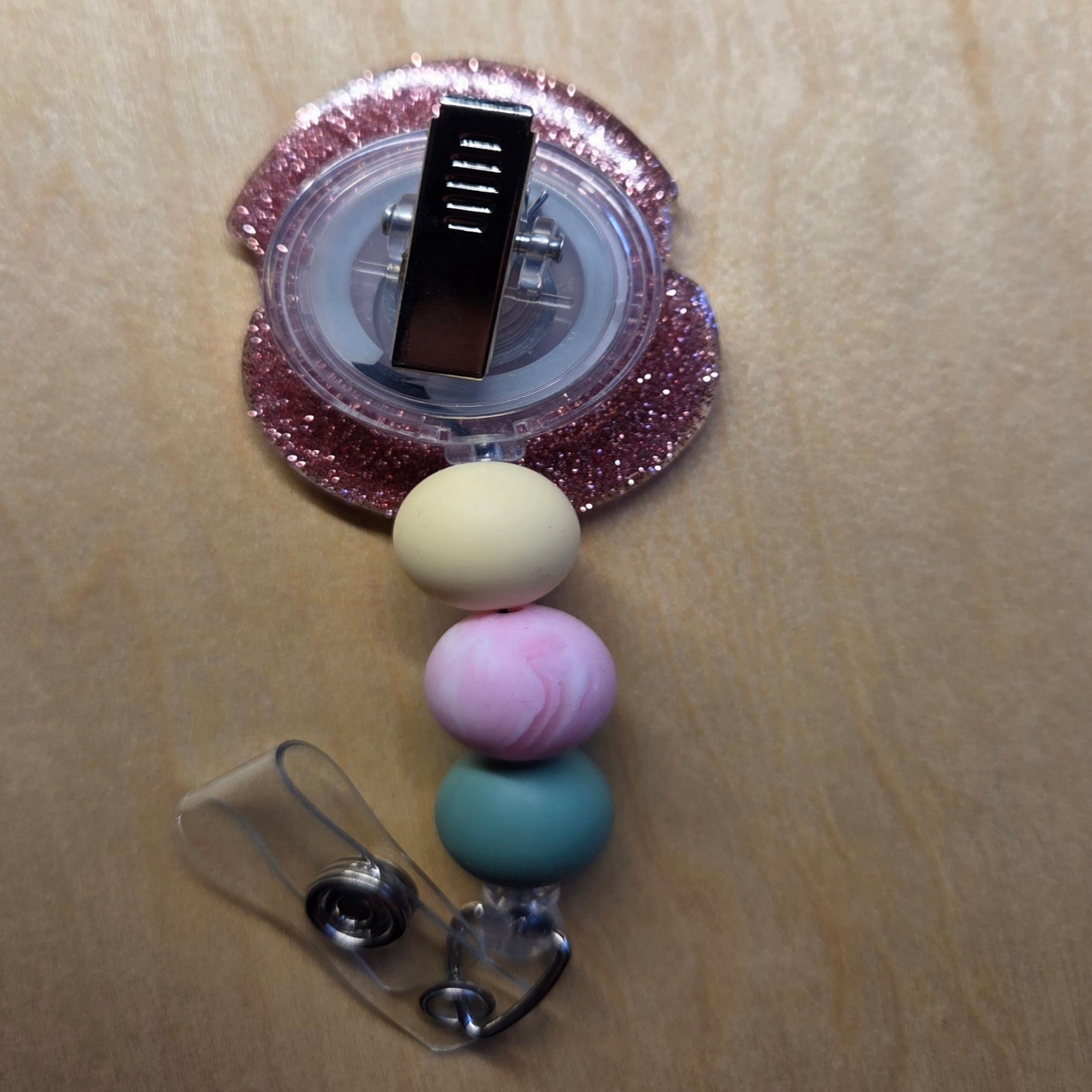 Colorful beaded badge holder with a clip on a beige background