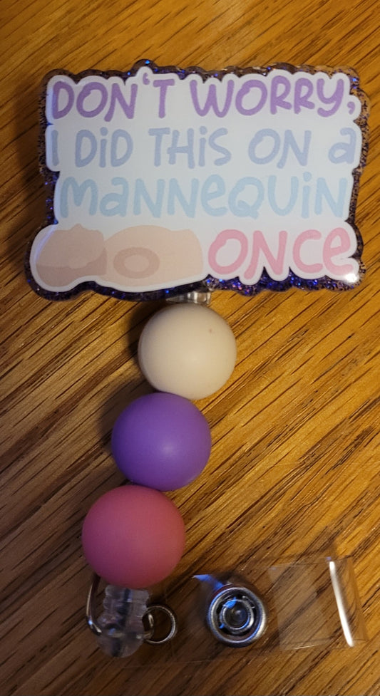 This badge reel has an image of a CPR mannequin with the fun phrase, Don't Worry I Did This On A Mannequin Once on the front with a purple glitter base on the back adorned with 3 coordinating silicone beads.