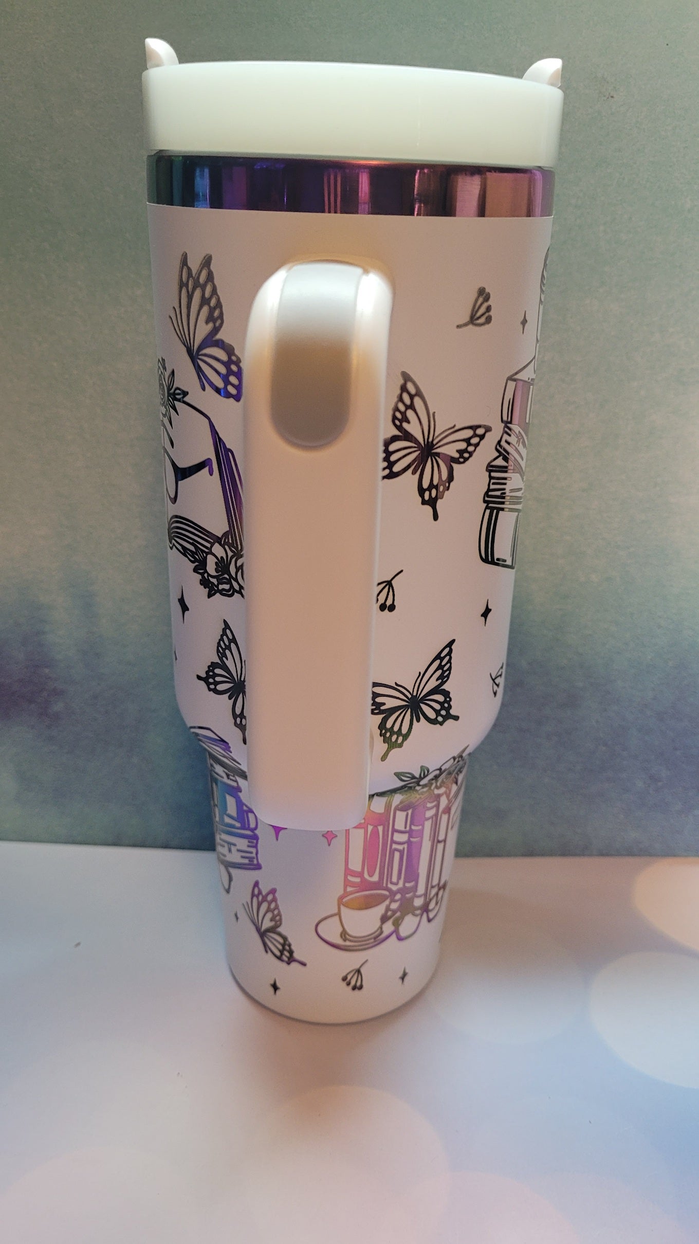White tumbler with butterfly design on a white background
